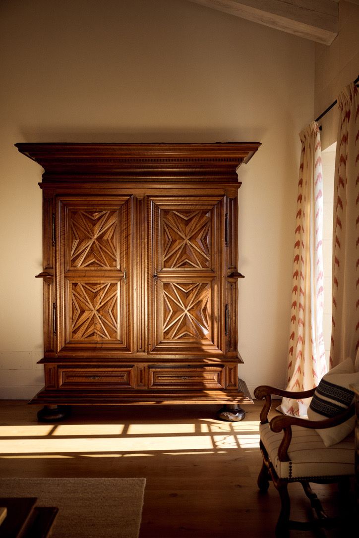 A carved walnut armoire in the afternoon sun