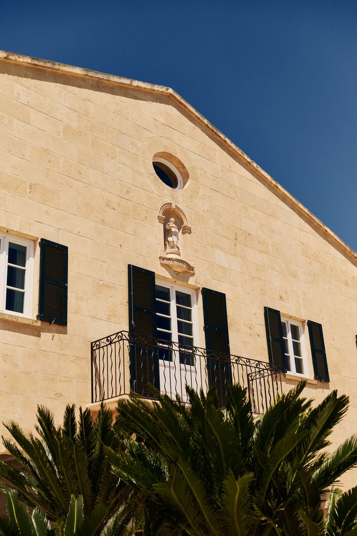 The façade with its statue niche, palms below